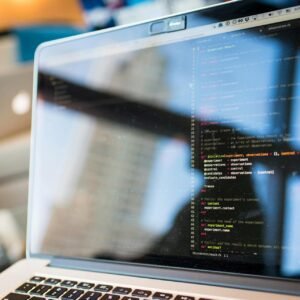 Laptop displaying code with reflection, perfect for tech and programming themes.